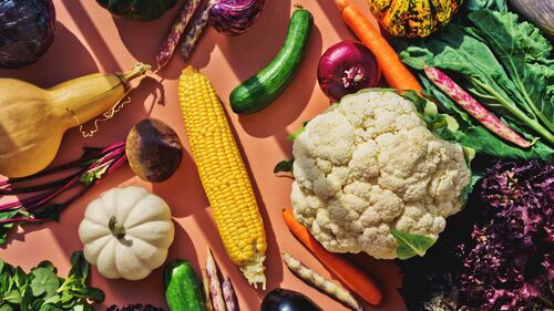 A vibrant bowl of gut-healthy foods including yogurt, berries, nuts, and leafy greens.