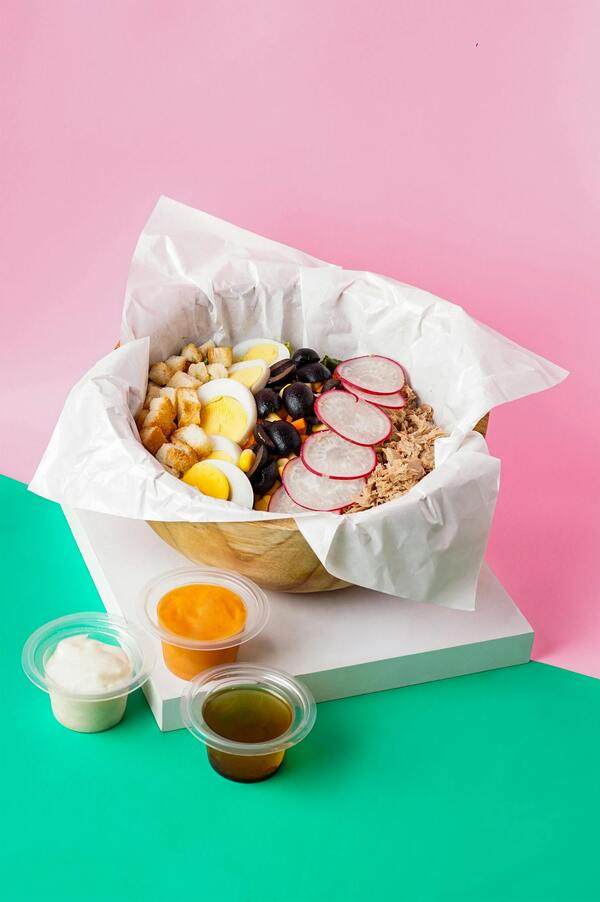 A person looking tired at their desk, surrounded by coffee cups.